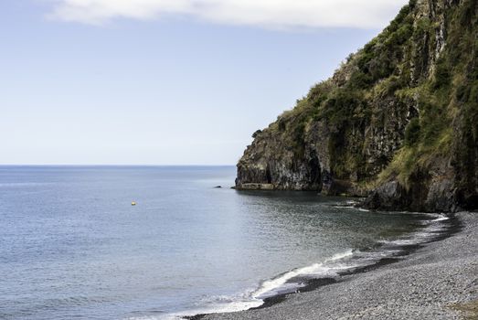 madeira coastline with ocean and rocks with calm sea and rocky beack