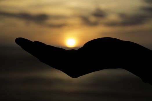 female hand with the sun during sunset on her hand