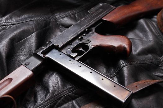 Old USA submachine gun closeup on black leather background