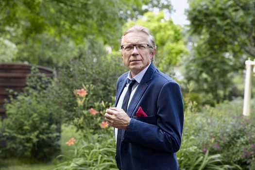 Portrait of a worried middle-aged man in the garden. Natural sunlight.