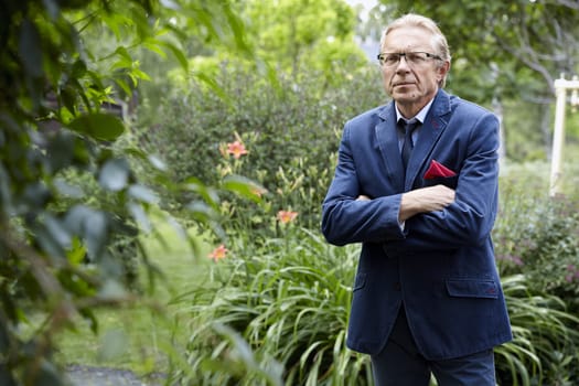 Portrait of a pensive middle-aged man in the garden. Natural sunlight.