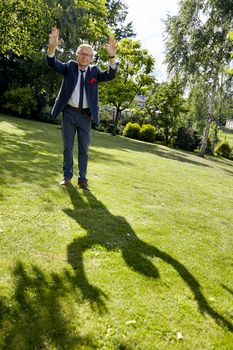 Shot of gesticulate man in the garden at sunny day. Natural sunlight.