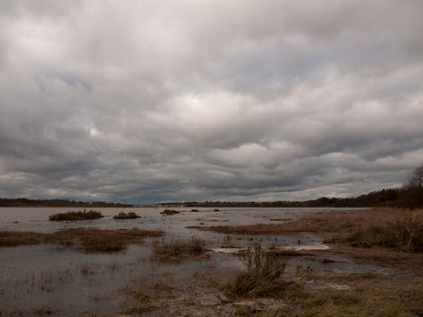 moody sky overcast autumn winter bay water ocean trees; essex; england; uk