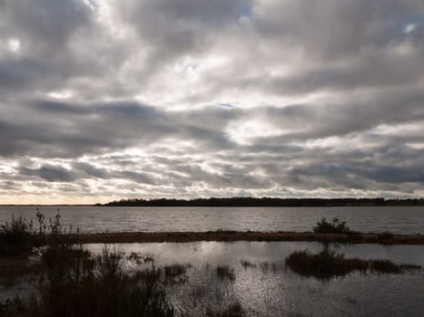 moody sky overcast autumn winter bay water ocean trees; essex; england; uk