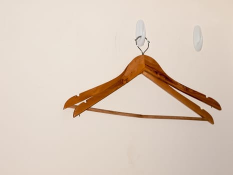 two wooden clothes hangers on white wall background empty