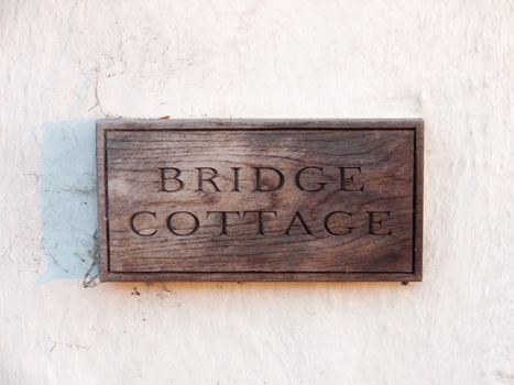 close up wooden house sign bridge cottage carved special unique; essex; england; uk
