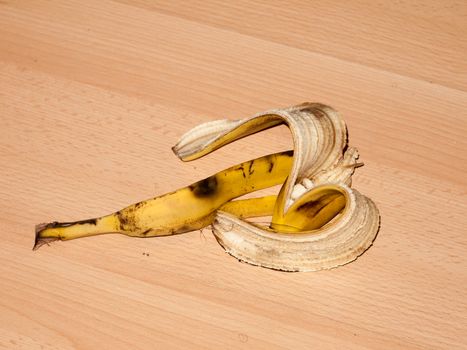 peeled banana skin on wooden laminate flooring danger hazard food; essex; england; uk
