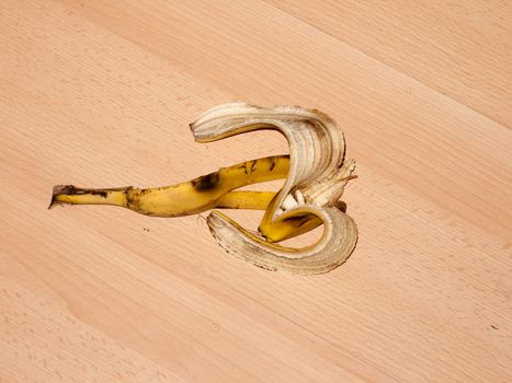 peeled banana skin on wooden laminate flooring danger hazard food; essex; england; uk