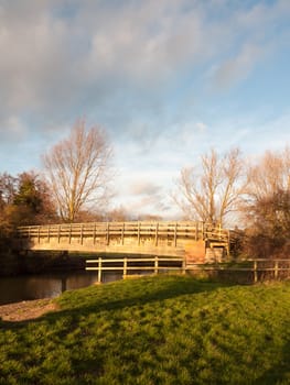 old wooden walking bridge over water sunset landscape; essex; england; uk