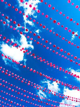 Pink balls decoration against blue sky and clouds. Ste-Catherine street, gay village neighborhood in Montreal (Quebec, Canada).