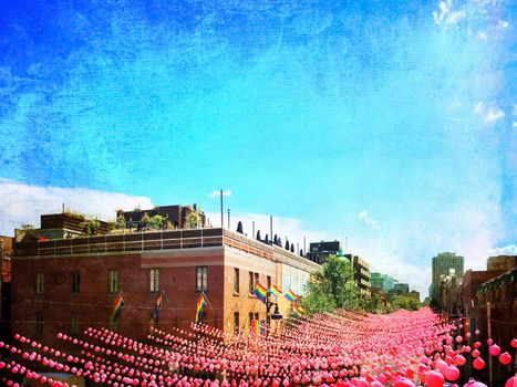 Retro style image of a street in gay neighborhood decorated with pink balls. Annual summer installation in gay village on Ste-Catherine street, Montreal (Quebec, Canada).