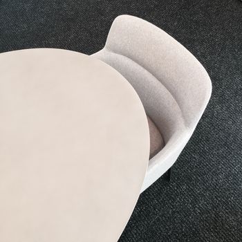 Round table and comfortable fabric chair. Contemporary furniture design.