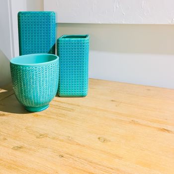 Turquoise ceramic vases on a wooden table. Contemporary home decor.