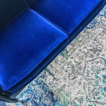 Luxurious blue velvet sofa and a fashionable rug. Classy furniture.