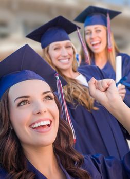 Happy Graduating Group of Girls In Cap and Gown Celebrating on Campus.