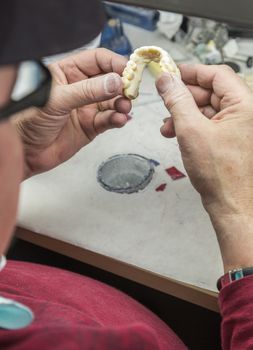 Male Dental Technician Working On A 3D Printed Mold For Tooth Implants In The Lab.