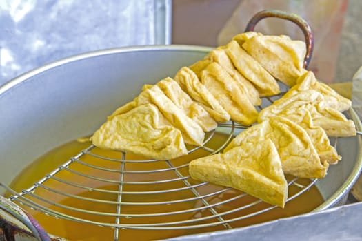 Fried tofu with hot oil on grille thai and chinese food.