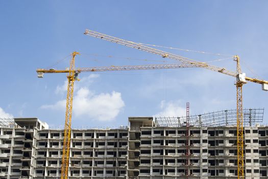 Inside place for many tall buildings under construction and cranes under a blue sky