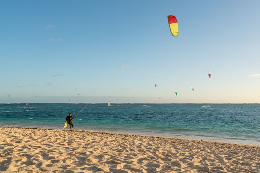 The group of kitesurfing on the beach at Mauritius Island.