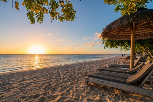 awesome beach at Mauritius island with wooden parasol in the right side, amazing sunset.