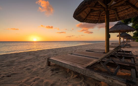 Beautiful beach at Mauritius island with wooden parasol in the right side, amazing sunset.