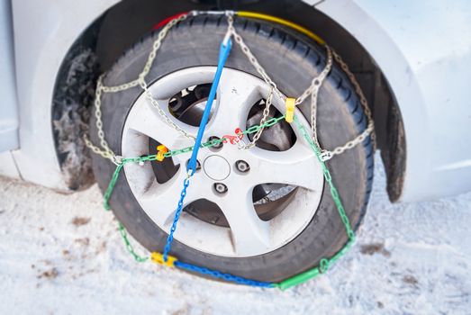 wheel of a car with mounted winter chains. Safety concept