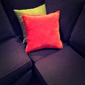 Bright velvet cushions on a dark textile sofa. Modern design.