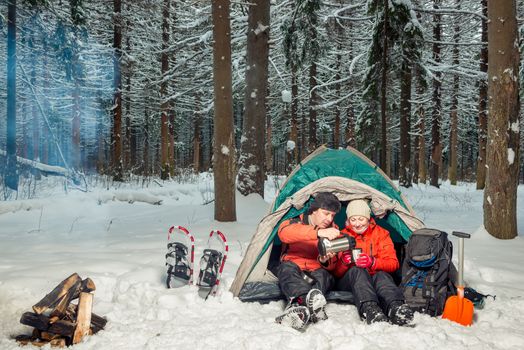 desperate tourists with tea at halt in the winter cold forest