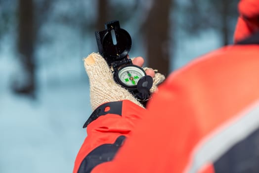 tourist with a compass in his hand is looking for a way home