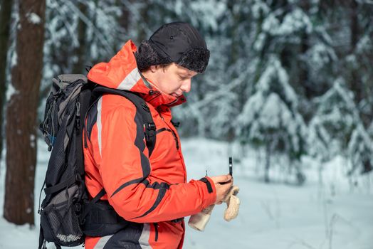 tourist with a compass and a backpack got lost in the winter forest