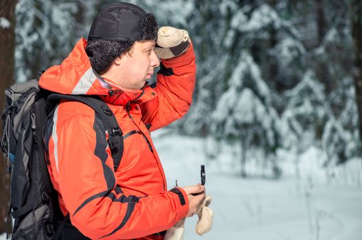 a man with a backpack and a compass got lost in a snowy forest
