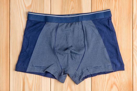 blue new cotton panties for boy clothes on wooden boards top view