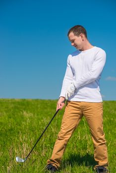 portrait of a golfer in full length with a stick in the field