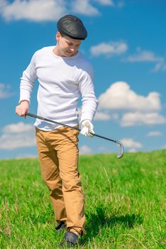 portrait of a golf player with a golf club on a sunny day on the field