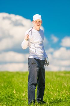 vertical portrait of a successful golfer with a golf club in the field