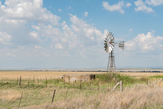 A farm scene with water-pumping windmill and dam next to the R703-road between Verkeerdevlei and Excelsior in the Free State Province of South Africa