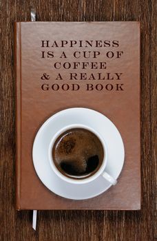 HAPPINESS  IS A CUP OF  COFFEE & A REALLY  GOOD BOOK . A book with a motivational quote and a cup of coffee