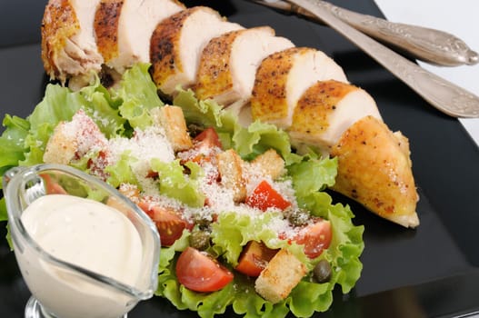 Sliced baked chicken breast with garnish  a la Caesar. 