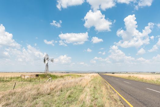 A farm scene with water-pumping windmill and dam next to the R703-road between Verkeerdevlei and Excelsior in the Free State Province of South Africa