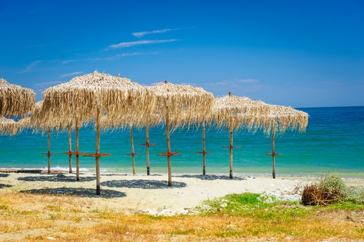 umbrellas made from reed or cane, at empty beach