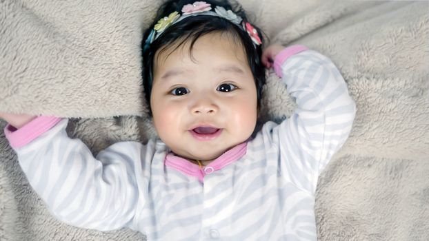 Asian cute baby girl lying on the bed