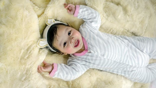 Asian cute baby girl lying on the bed