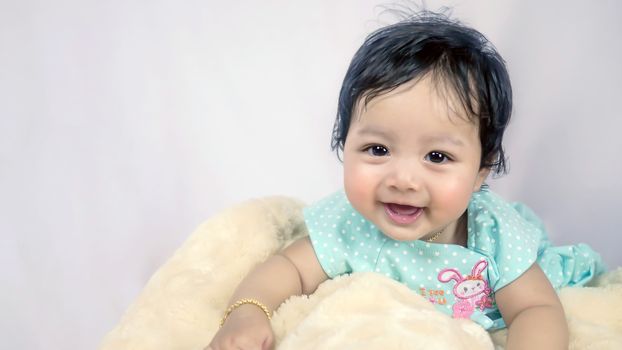 Asian Smiling baby girl crawling in bedroom