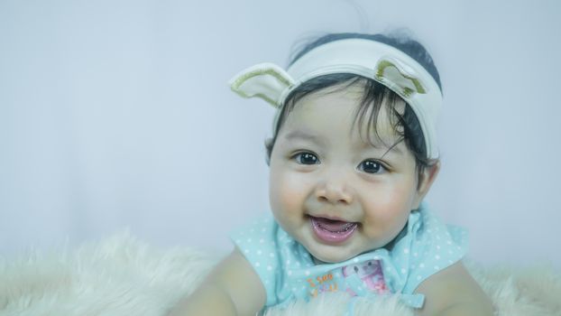 Asian Smiling baby girl crawling in bedroom