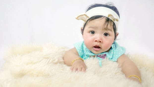 Asian Smiling baby girl crawling in bedroom