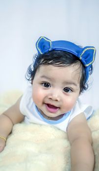 Asian Smiling baby girl crawling in bedroom