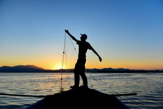 silhouette of man fishing