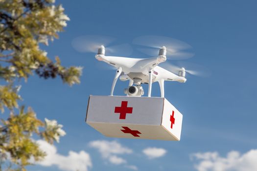 Unmanned Aircraft System (UAS) Quadcopter Drone Carrying First Aid Package In The Air.