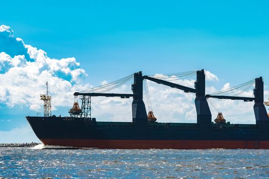 Merchandise import. Large blue cargo ship moving to Riga port