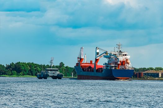 Merchandise import. Large blue cargo ship moving to Riga port